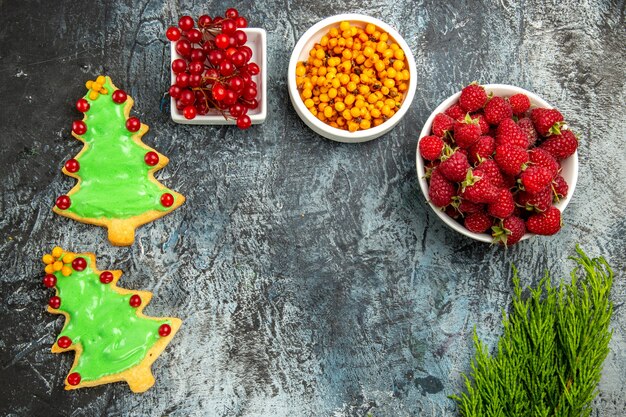 Top view fresh cranberries with raspberries and tree shaped biscuits