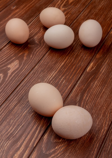 Free photo top view of fresh cream colored chicken eggs isolated on a wooden background