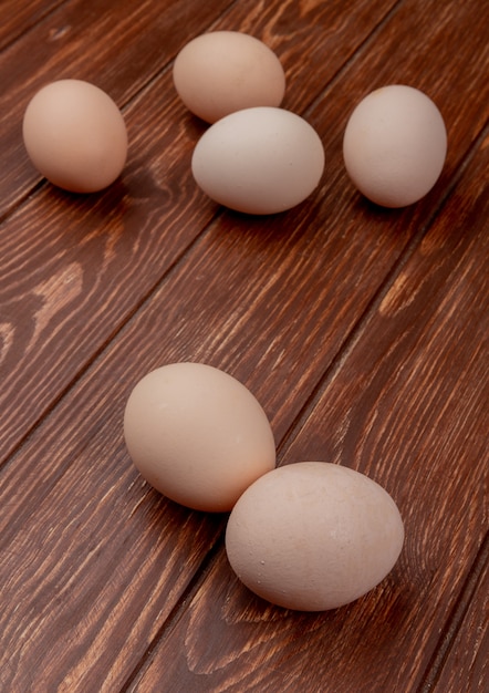 Top view of fresh cream colored chicken eggs isolated on a wooden background