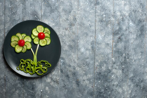 회색 책상에 상위 뷰 신선한 오이 꽃 디자인 샐러드