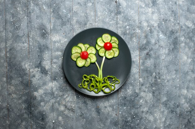 灰色のスペースに新鮮なキュウリの花がデザインしたサラダの上面図