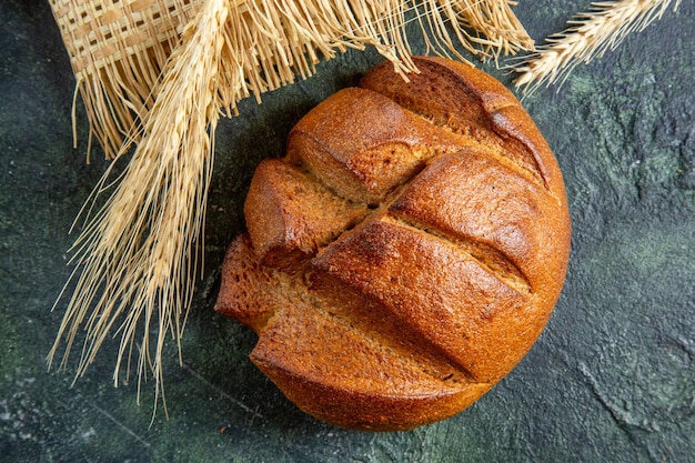 Top view fresh dark bread on dark desk