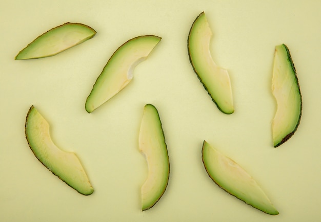 Free photo top view of fresh and delicious avocado slices isolated on light green