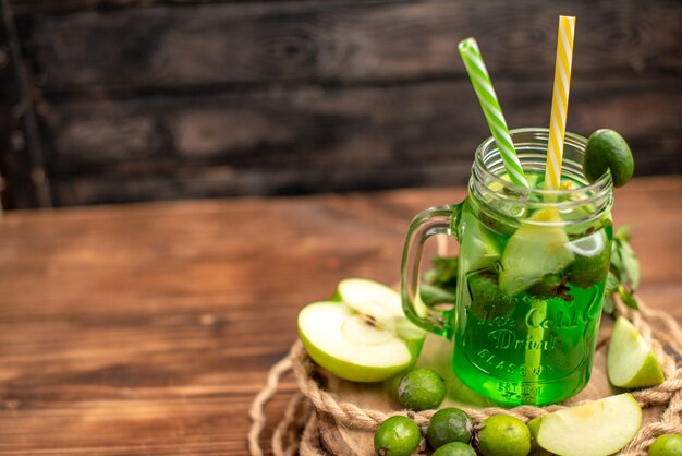 Top view of fresh delicious fruit juice served with apple and feijoas on a wooden cutting board