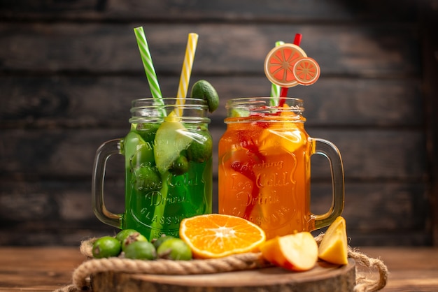 Top view of fresh delicious fruit juices served with apple and feijoas oranges on a wooden cutting board