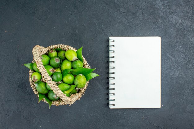 어두운 표면에 노트북 바구니에 상위 뷰 신선한 feijoas