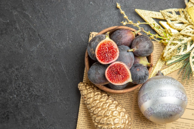 Free photo top view fresh figs with christmas tree toys on dark background