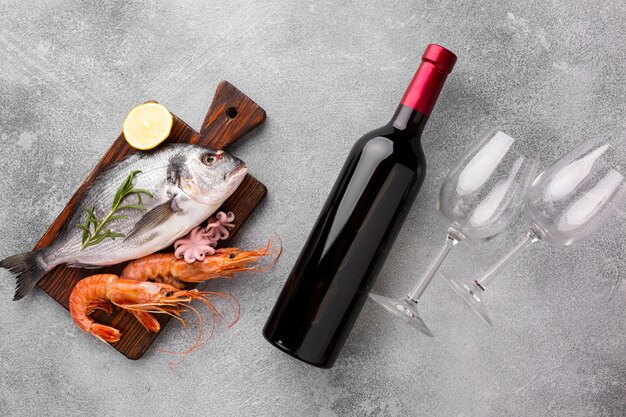 トップビューの新鮮な魚とワインのボトル