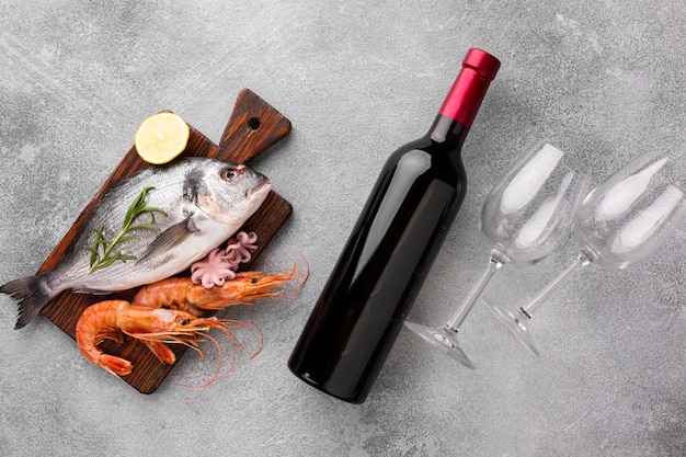 トップビューの新鮮な魚とワインのボトル