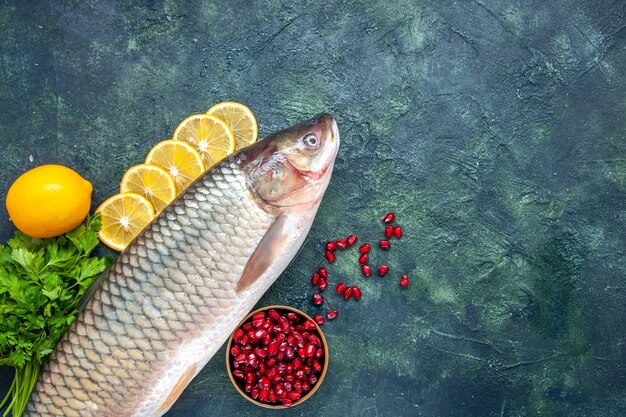 Top view fresh fish lemon slices pomegranate seeds bowl on table free place