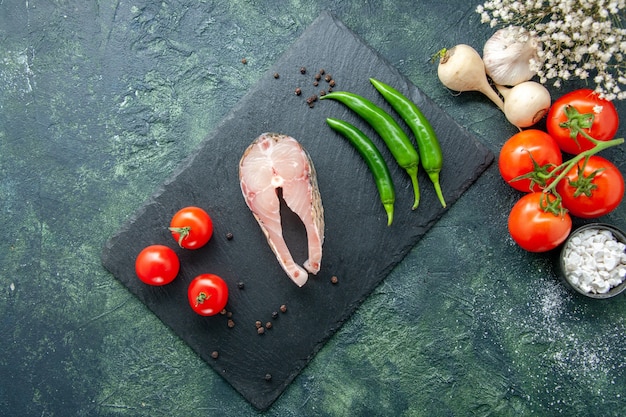 Вид сверху ломтик свежей рыбы с помидорами и зеленым перцем на темном фоне морепродукты морепродукты мясо океана морская еда вода перец блюдо еда