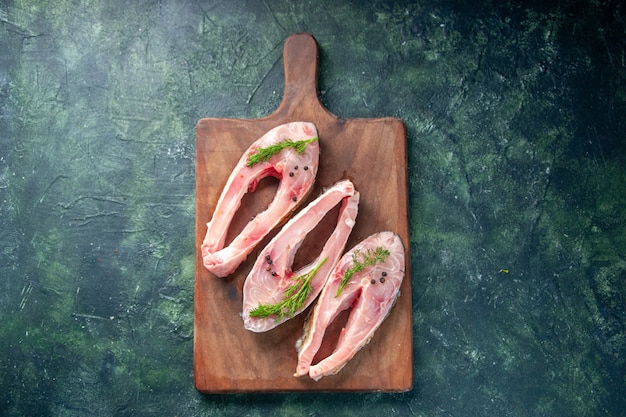 top view fresh fish slices on dark blue background