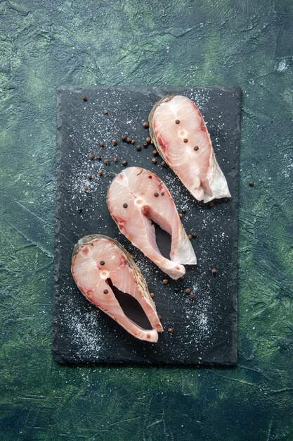 어두운 테이블에 상위 뷰 신선한 생선 조각 해산물 바다 고기 바다 식사 요리 음식 샐러드 물 후추