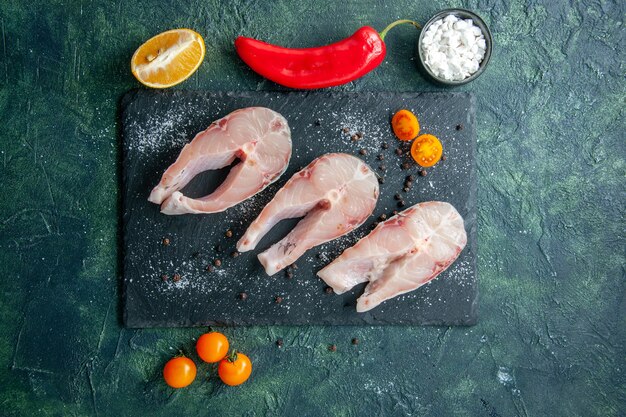 Top view fresh fish slices on dark table seafood ocean meat sea meal dish salad water pepper food