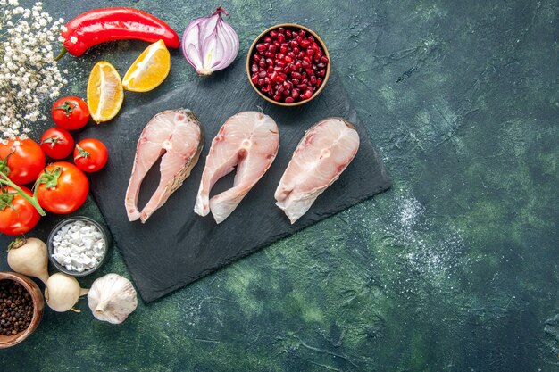 Top view fresh fish slices with red tomatoes on dark background seafood ocean meat sea meal dish food salad water pepper