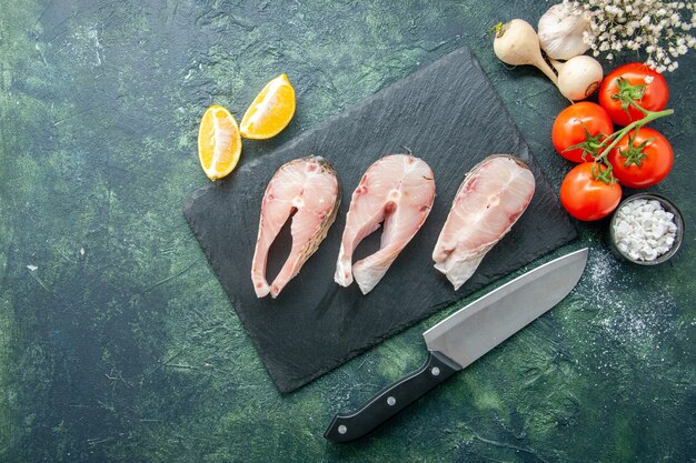 Top view fresh fish slices with red tomatoes on a dark background seafood ocean meat sea meal water pepper dish food salad