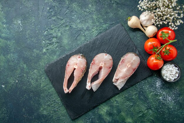 Top view fresh fish slices with red tomatoes on dark background seafood ocean meat sea meal water pepper dish food salad