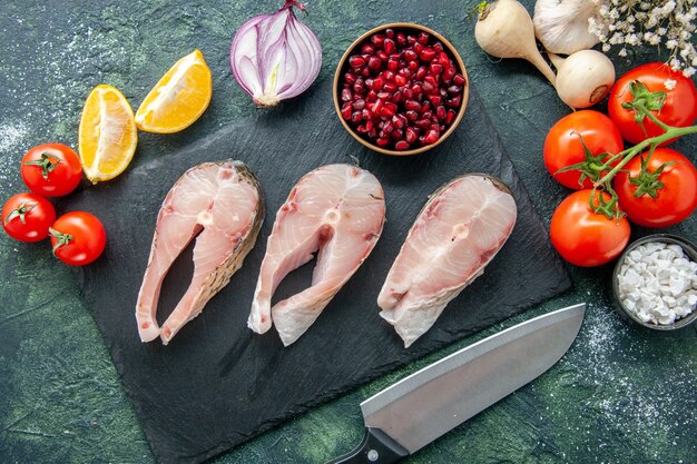 어두운 표면에 빨간 토마토와 상위 뷰 신선한 생선 조각 해산물 바다 고기 바다 식사 물 후추 음식 샐러드