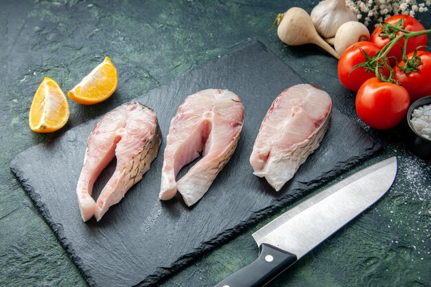 Top view fresh fish slices with red tomatoes on dark surface seafood ocean meat sea water pepper dish food salad