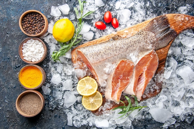 Foto gratuita vista dall'alto fette di pesce fresco con condimenti e ghiaccio su sfondo scuro ristorante cena pasto frutti di mare salute carne cibo oceanico