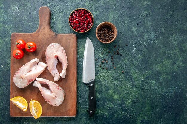 Top view fresh fish slices with tomatoes and lemon on dark background seafood ocean meat sea meal water pepper dish food free space