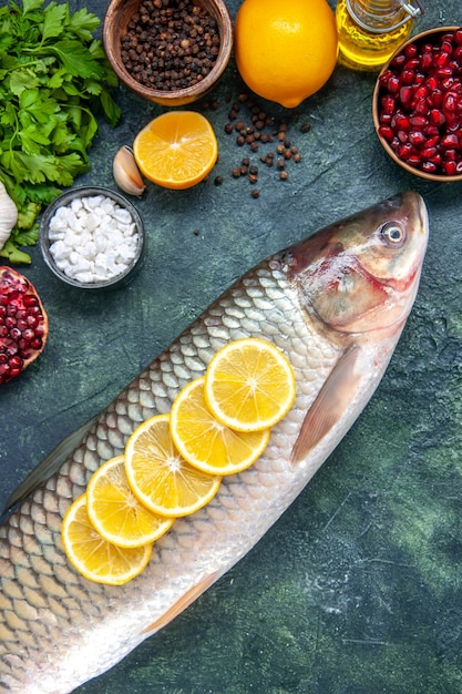 Vista dall'alto pesce fresco con fette di limone sul tavolo della cucina