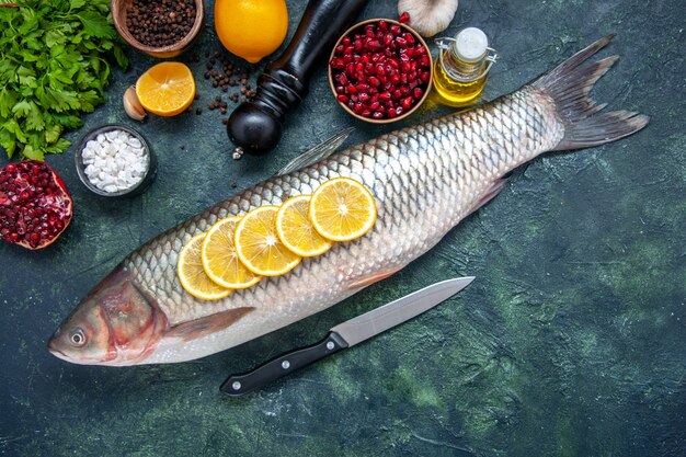 Top view fresh fish with lemon slices knife on kitchen table