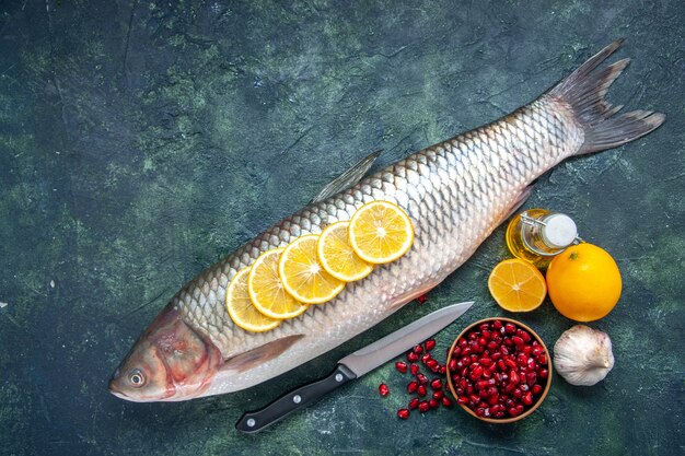 レモンスライスと新鮮な魚の上面図コピー場所とキッチンテーブルのザクロの種のボウルをナイフ