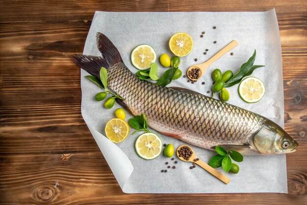 Vista dall'alto di pesce fresco con fette di limone sul tavolo in legno cibo piatto di frutti di mare oceano