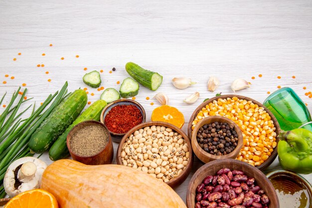 Top view of fresh foods and spices vegetables on the bottom on white table