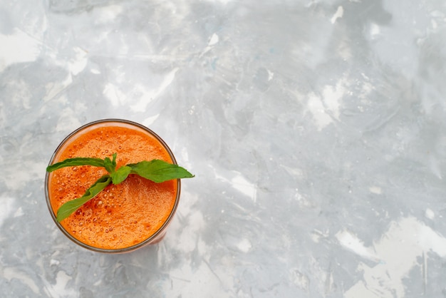 Foto gratuita cocktail della frutta fresca di vista superiore dentro vetro lungo con la foglia su gray