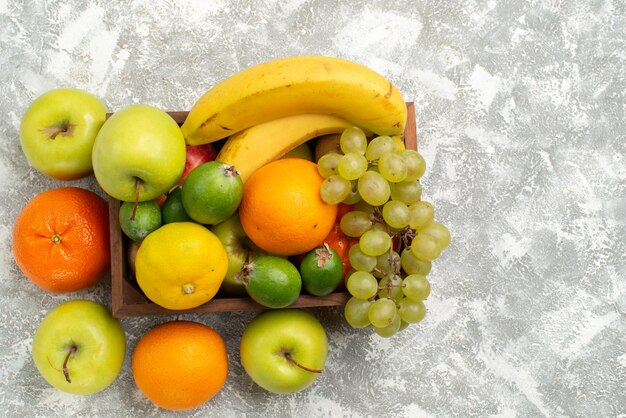 Top view fresh fruit composition bananas grapes and feijoa on a hite background fruits mellow vitamine health fresh