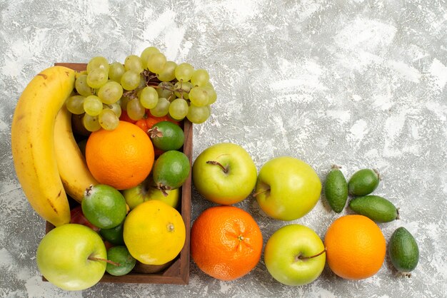 Top view fresh fruit composition bananas grapes and feijoa on white background fruits mellow vitamine health fresh