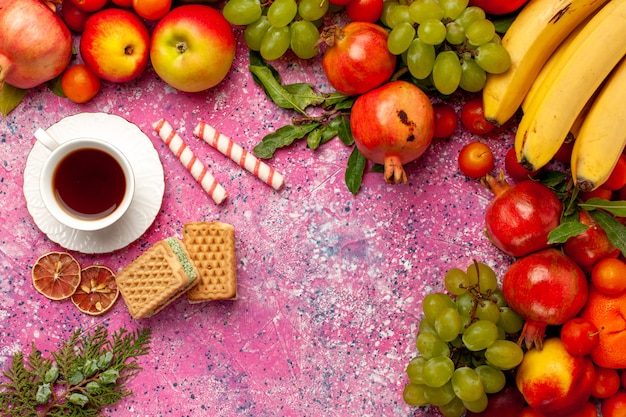 분홍색 표면에 차와 와플 상위 뷰 신선한 과일 구성 다채로운 과일