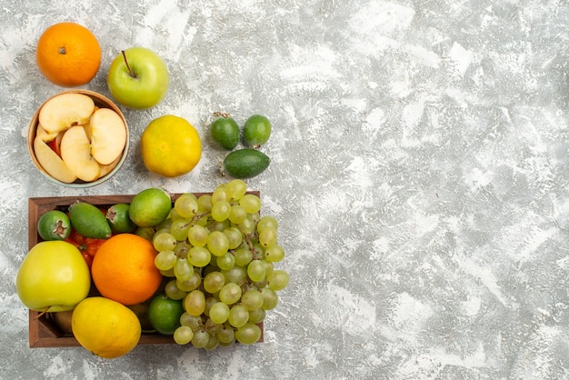 Top view fresh fruit composition grapes feijoa and apples on white background fruit exotic citrus fresh