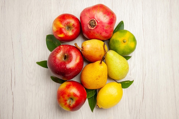Вид сверху свежие фрукты яблоки груши и другие фрукты на белом столе фрукты спелое дерево цвет мягкий много свежих