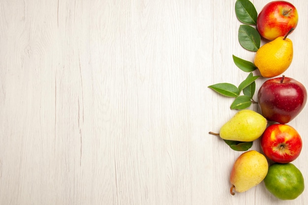 Foto gratuita vista dall'alto frutta fresca mele e pere su scrivania bianca frutta albero maturo colore morbido molti freschi