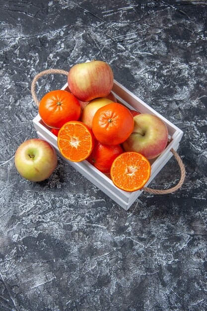 Top view fresh fruits in box cinnamon sticks on dark background with free space