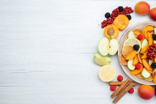トップビューの新鮮な果物のカラフルで熟した木製の机と白い背景の果物色の食品写真