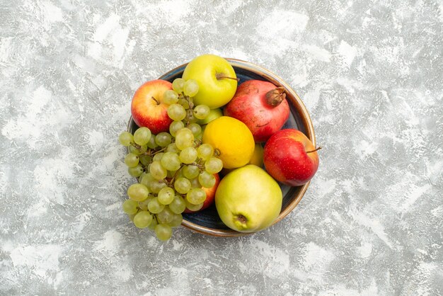 Вид сверху свежие фрукты композиция яблоки, виноград и другие фрукты на белом фоне свежие спелые фрукты спелого цвета витамин