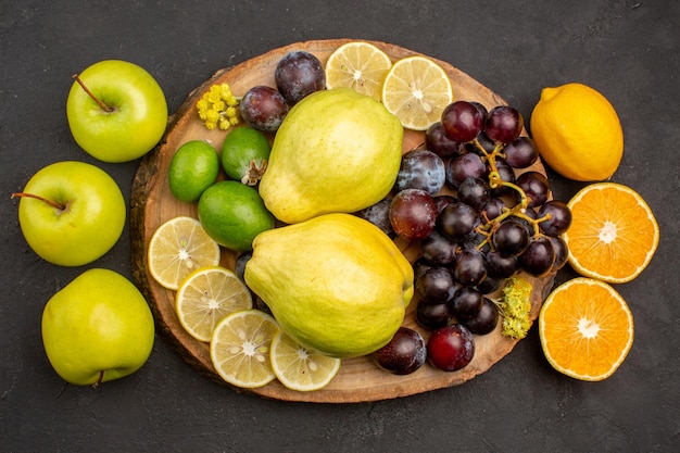 Top view fresh fruits composition mellow and ripe fruits on a dark surface