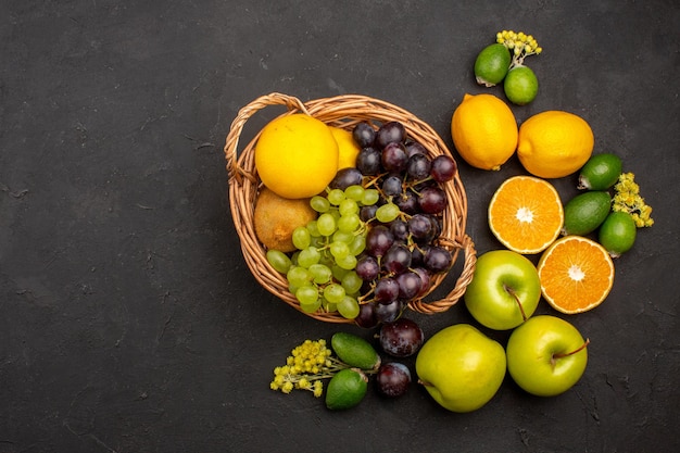 Vista dall'alto composizione di frutta fresca frutta affettata e matura dolce sulla scrivania scura frutta vitamina fresca dolce matura
