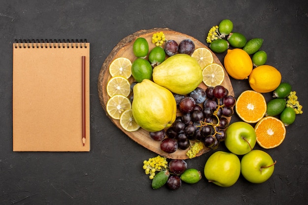 Top view fresh fruits composition mellow sliced and ripe fruits on dark surface fresh ripe fruits vitamine mellow