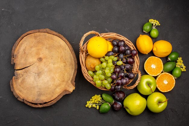 Top view fresh fruits composition mellow sliced and ripe fruits on a dark surface fruit fresh vitamine mellow ripe