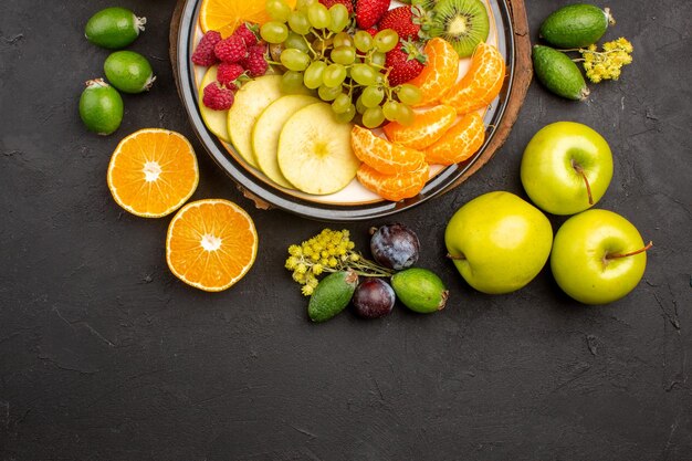 Top view fresh fruits composition mellow sliced and ripe fruits on dark surface ripe fruit vitamine fresh mellow