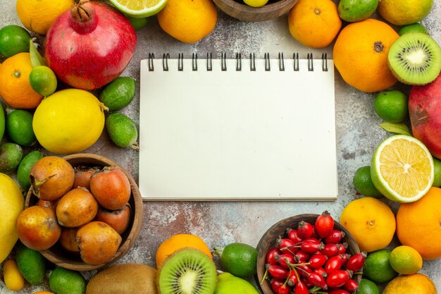 Вид сверху свежие фрукты разные спелые фрукты на белом фоне вкусные фото спелые ягоды диета цвет дерева здоровье