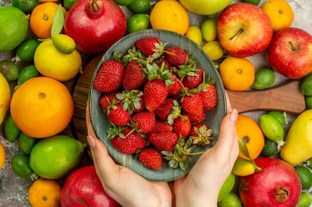 Top view fresh fruits different ripe and mellow fruits on the white background health tasty color photo diet berry