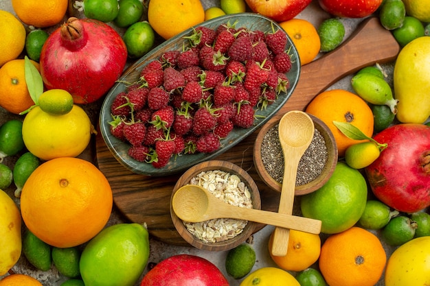 Vista dall'alto frutta fresca diversi frutti maturi e morbidi sullo sfondo bianco foto gustosa dieta a colori salute delle bacche