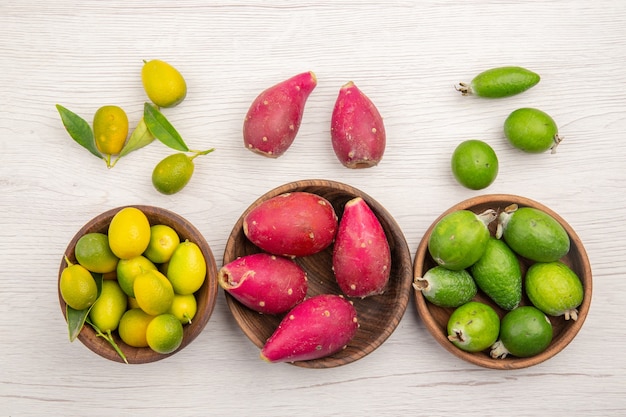 무료 사진 밝은 흰색 배경에 신선한 과일 feijoas 및 기타 과일의 상위 뷰