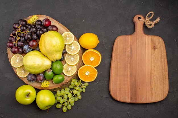 어두운 표면에 잘 익은 신선한 과일 건강 비타민 나무에 신선한 과일 포도 레몬 슬라이스 자두와 모과